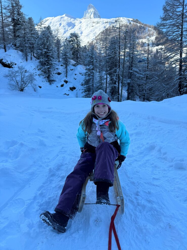 Zoey sledding in Zermatt Switzerland with Matterhorn in the background