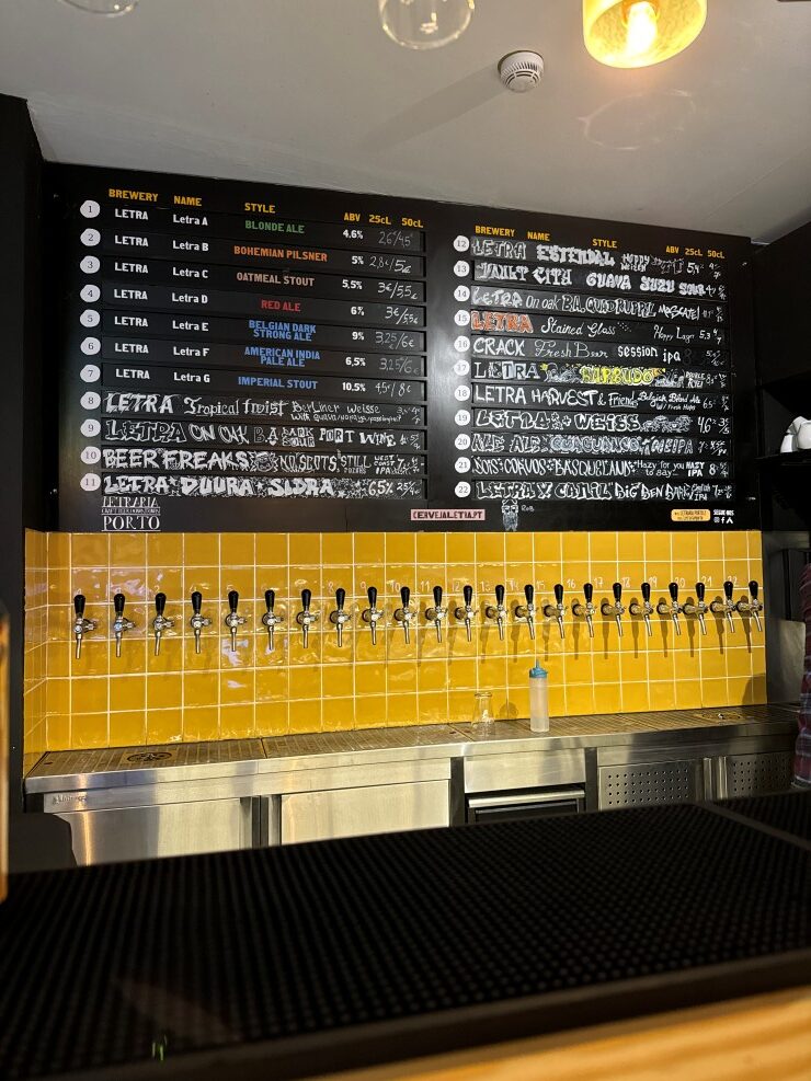 Craft beer taps on draft at Letraria brewpub downtown in Porto, Portugal