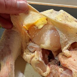 Placing butter and season under the skin of a roast chicken