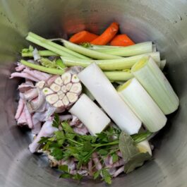 Ingredients in a pot with the herbs for the ultimate homemade chicken stock