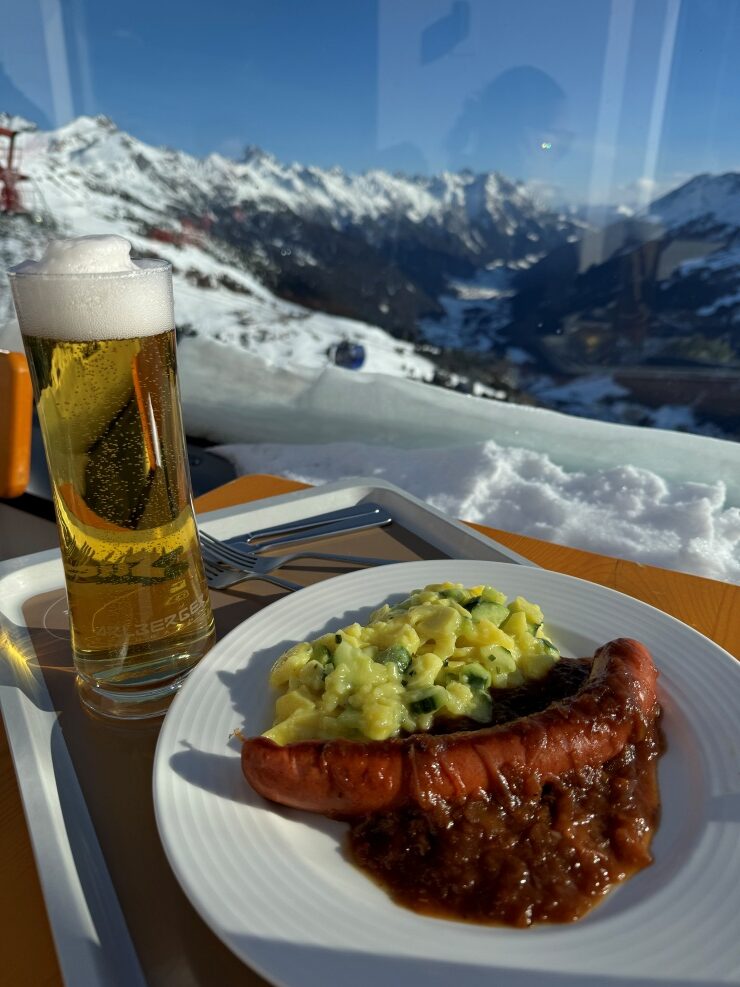 Enjoying Austrian fare of bratwurst, potato salad and onion sauce from the Glazig Lodge in St. Anton ski resort Austria