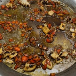 Red bell pepper, onion, cuttlefish sauteing for Spanish Paella