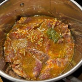 Braising pork chop meat in a wine and garlic marinade for tender bifana pork chop sandwiches