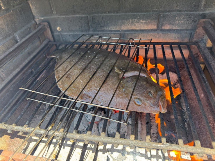 Grilled rodovalho cooked over charcoal flames in the Algarve of Portugal.